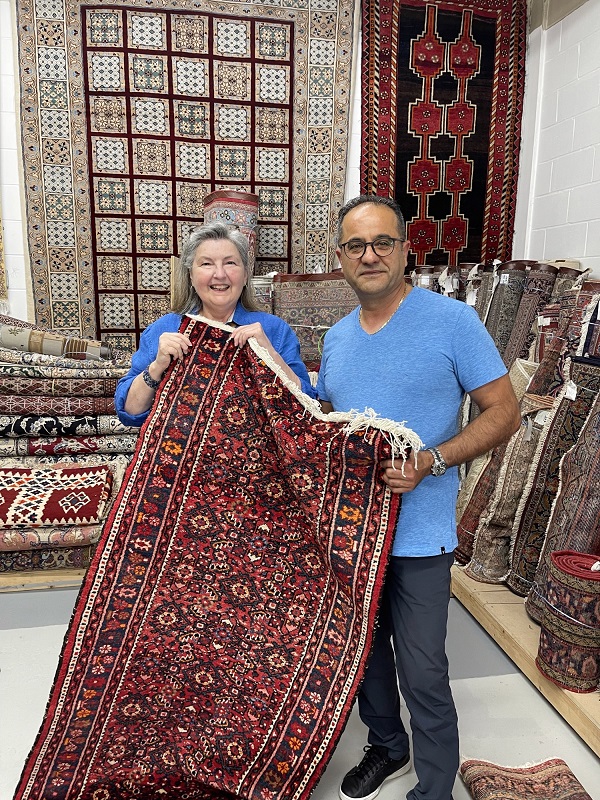 Client and Hamid holding Persian rug sold 