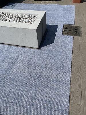 A rug for outdoor terrace resized and bound to fit the fire pit and water drain